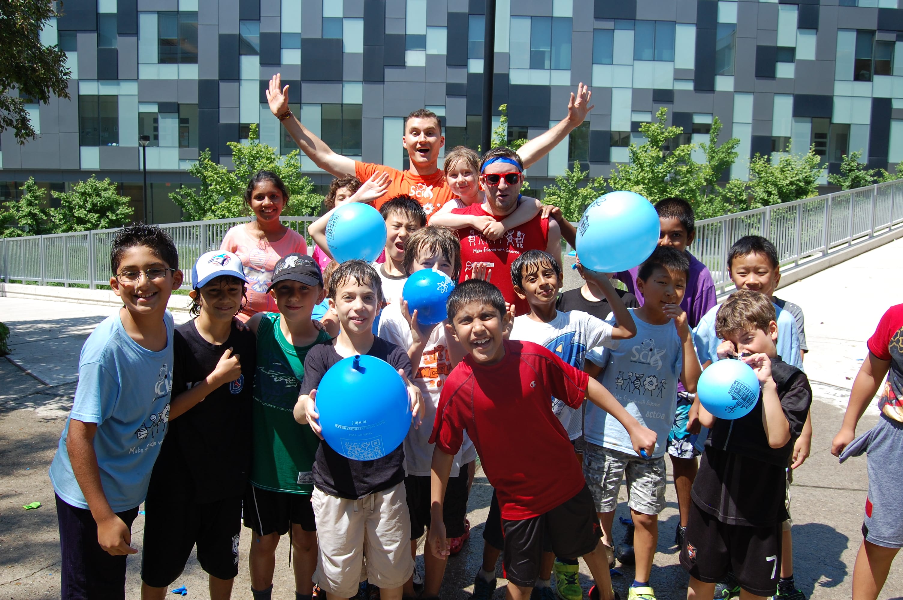 Group of volunteers and participants smiling and holding balloons posed for camera.